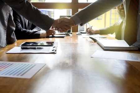 Group of businessman handshake  on wood table with computerの写真素材