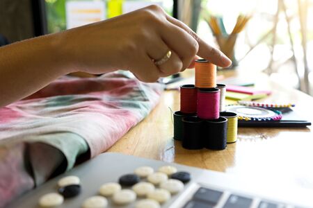 young fashion designer work with fabric cloth on the wood table