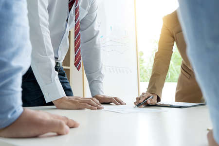 businessman and businesswoman stand all hand on table in business discussion teamwork man woman working in office white toneの写真素材