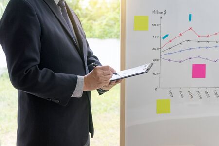 businessman stand presentation in business group meeting show chart graph on board の写真素材