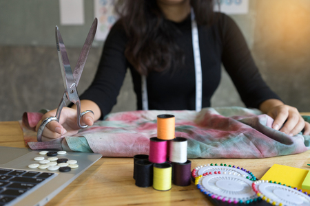 young fashion designer work with fabric cloth on the wood table or graphic designerの写真素材