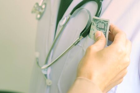 Business man or patient give bribe to the doctor concept corruption の写真素材