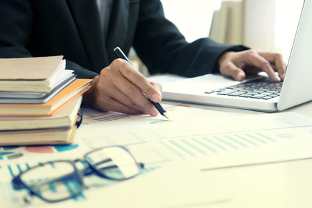 Business businessman work on the table use computer and tablet with graph chart of marketing analysis job.の写真素材