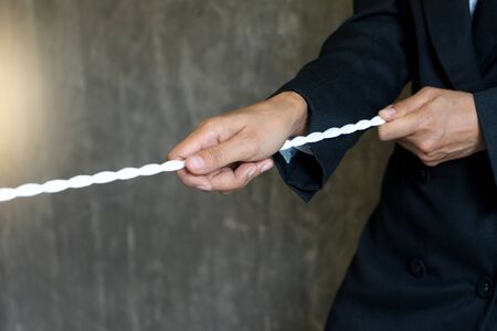 businessman force to pull white rope concept business competition for win の写真素材