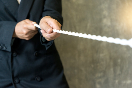 businessman force to pull white rope concept business competition for win の写真素材