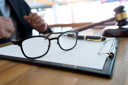 lawyer  judge  or Auction show  gavel in the room or office focus on eyeglass
の写真素材