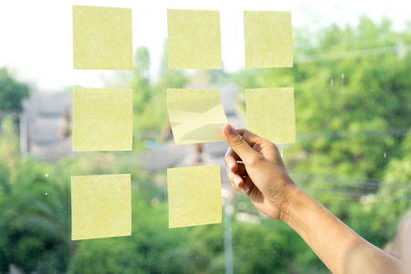 Woman doctor stand infront of yellow note on window glass