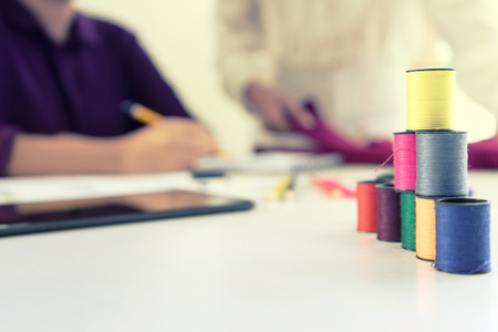  professional Fashion designer working and drawing sketches on the table with computer tablet and color charts.の写真素材