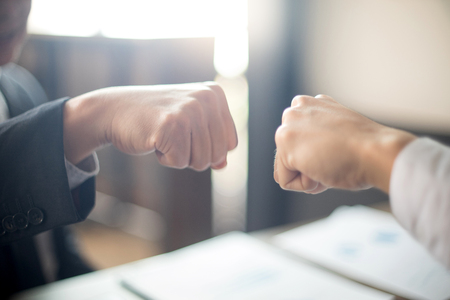 two business man use hand to fist bump for succes teamwork coporate の写真素材