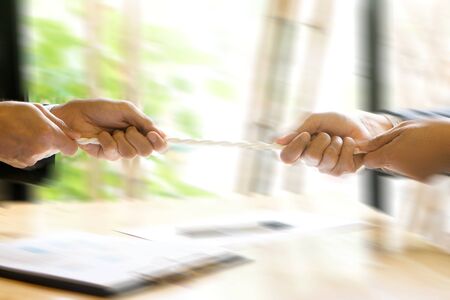 Two businessman 2 side hold and pull the rope for win another side business concept competitionの写真素材
