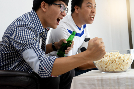 Group of young people man  watch Football match on tv broadcast program  cheer and existingの写真素材