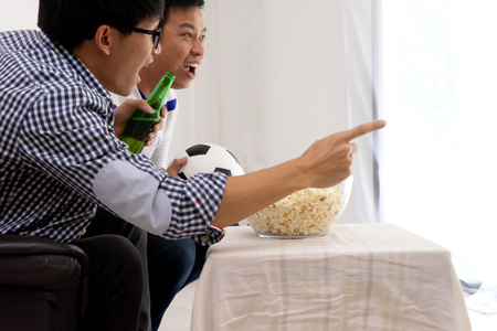 Group of young people man  watch Football match on tv broadcast program  cheer and existingの写真素材