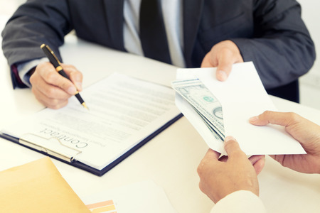 Business woman give bribe to the officer concept corruptionの写真素材