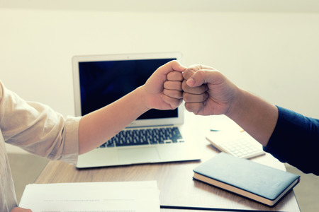 two business man woman use hand to fist bump for succes teamwork coporateの写真素材