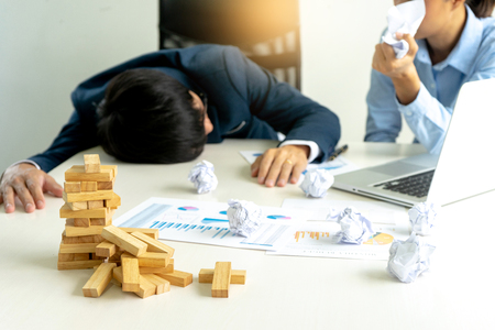businessman and businesswoman sad wood blog depressed on the table , business problem not to work or failure.の写真素材