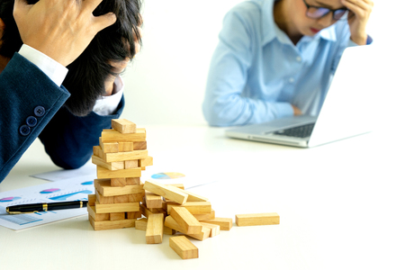 businessman and businesswoman sad wood blog depressed on the table , business problem not to work or failure.の写真素材
