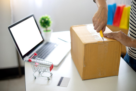 woman sit at computer table look at the product pack open or packing theme  about shopping online...