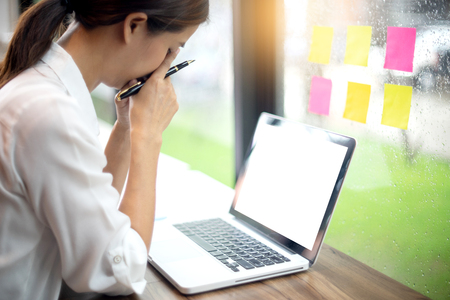 freelance worker work in the coffee shop alone and relax feel. with colorful note pad on the window , rain out side ,with white computer screen with clipping pathdの写真素材
