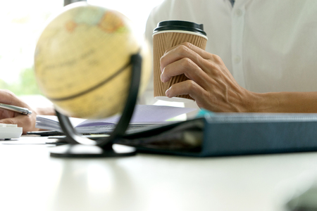 woman and man work for education or business on the table with notebook laptop and paper work color pen, with blur world map ball.の写真素材