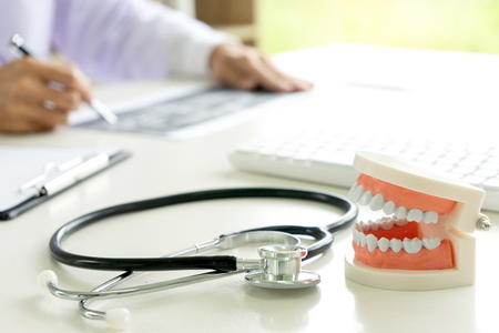 dentist work on the table with Denture and teeth x-ray paper for mouth health