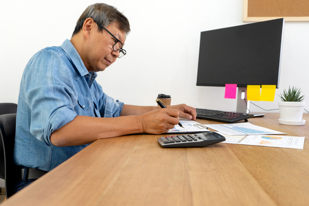 Senior person work for graphic design working on wood table with computer tablet electronic pen and color chartの写真素材