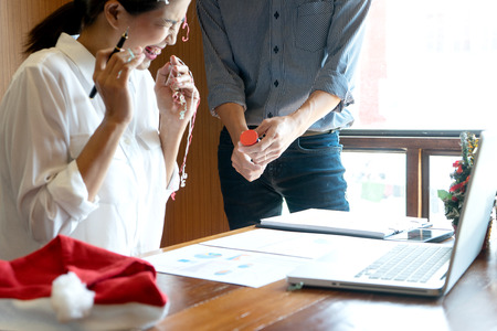 Businessman and Businesswoman celebrate in the office, near chrismas season 
or newyear. The office small decorate with gift and chrismas sign.の写真素材