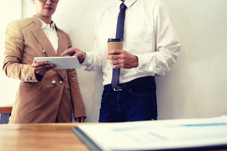 business businessman and woman stand in meeting analyses, on the table have chart graphy marketing plan in business project. sepia toneの写真素材