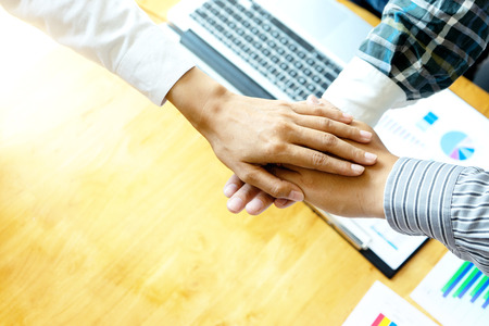businessman hand together with another business man woman on the table show their working about...