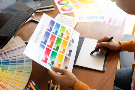 young woman work for graphic design working on wood table with computer tablet electronic pen and color chartの写真素材