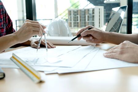 engineer or architectural project, two engineering or architect discussing and working on blueprint...