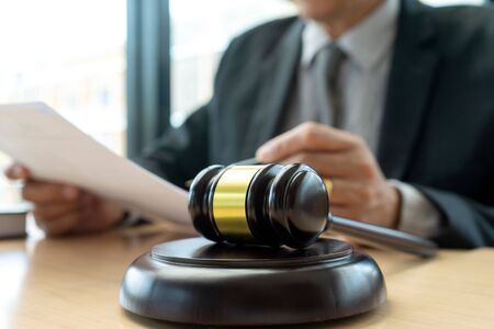 In the office of Judge or lawyer, there are balance and gavel on the table. Law firm Concept.