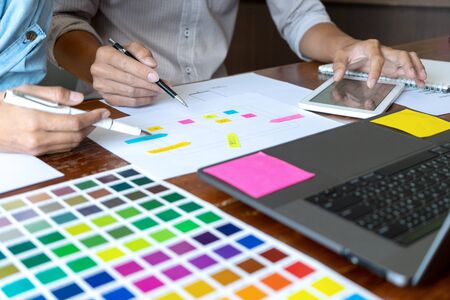 Group of young designer working in the office to design a new product, use color chart and computer laptop for new smartphone design conceptの写真素材