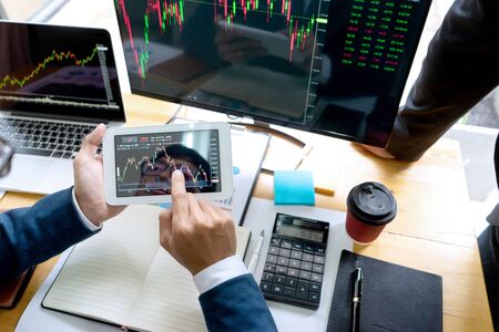 businessman sit at ther table looking at computer laptop in the office , they talking about stock market invest or talk with customerの写真素材