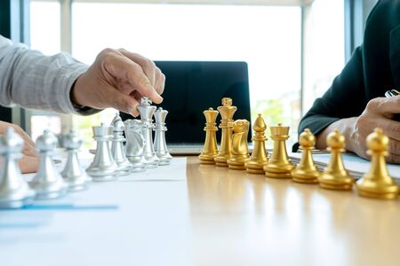 Businessman play chess on the marketing work place on office table for concept to win in strategy.の写真素材