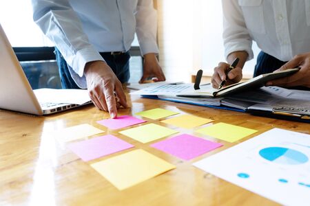 Businessman in business meeting businessman and businesswoman work on the table have graph chart and color notepad  paperの写真素材