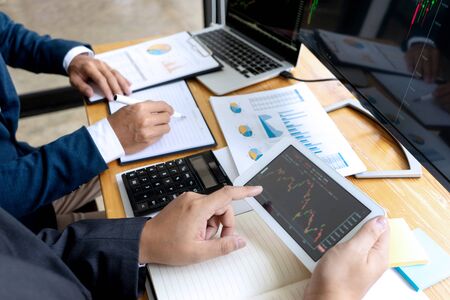 businessman sit at ther table looking at computer laptop in the office , they talking about stock market invest or talk with customerの写真素材