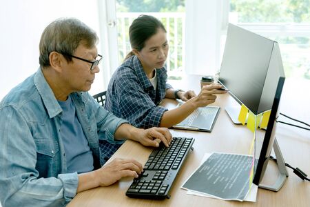 senior programmer work with Developing programming and coding technologies.  Programmer working with software on  many computer on the table in office. concept Website designの写真素材