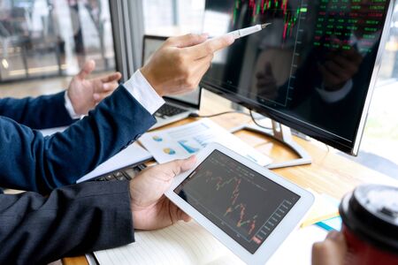 businessman sit at ther table looking at computer laptop in the office , they talking about stock market invest or talk with customerの写真素材