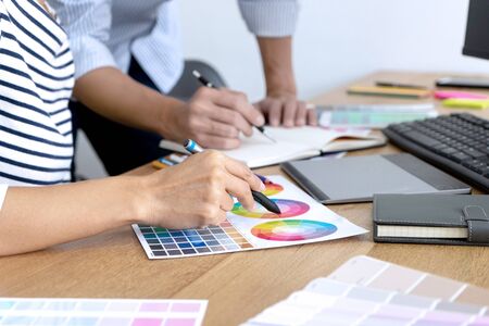 group of young worker for graphic design working on wood table with computer tablet electronic pen and color chart, graphic art conceptの写真素材
