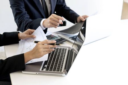 group of businessman sit at ther table looking at computer laptop in the office , they talking about stock market invest or talk with customerの写真素材