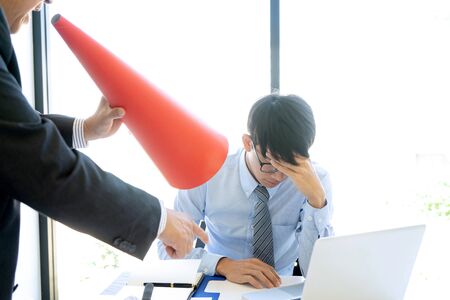 in the office Boss  use red Megaphone  shouting  with angry at his workers staff  who can not done good job. Worker feeling despair avoiding bothering clients.の写真素材
