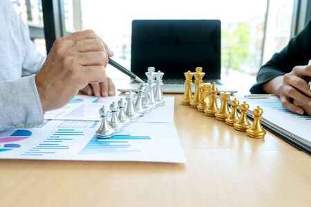 Businessman play chess on the marketing work place on office table for concept to win in strategy.の写真素材