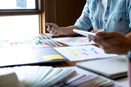 Group of young designer working in the office to design a new product, use color chart and computer laptop for new smartphone design conceptの写真素材