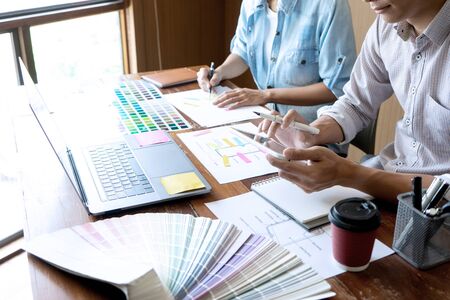 Group of young designer working in the office to design a new product, use color chart and computer...