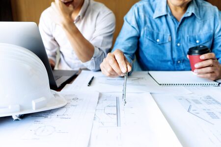 Group of engineering or architect discussing and working on blueprint with architect equipment,...