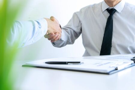 group of young buinessman handshake of Real estate agent and customers  in meeting attendance celebrating finished contract after about home insurance and investment loan, handshake and successful deal. insurance assurance quality concept.の写真素材