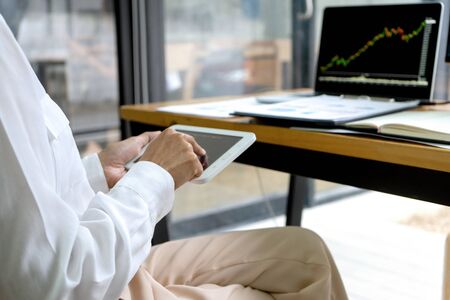 young businessman sit and look to the computer watch stock market. He excited when the stock market set index was the good pointの写真素材