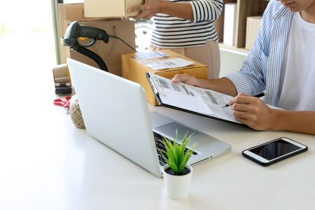 on line business  ecommerce concept, in office or home working prepare product in the box for send to customer who order by online. box for logistic with barcode scannerの写真素材