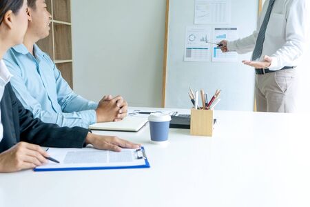 Young businessman stand in front of the group to present or business coaching to teach the technic to marketing business reach the target.の写真素材
