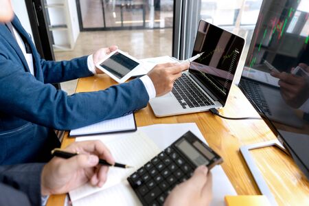 businessman sit at their table looking at computer laptop in the office, they talking about stock market invest or talk with customerの写真素材